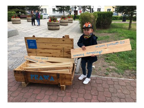 Zdjęcie chłopca trzymającego deseczkę z napisem Mam prawo do pomocy dorosłego